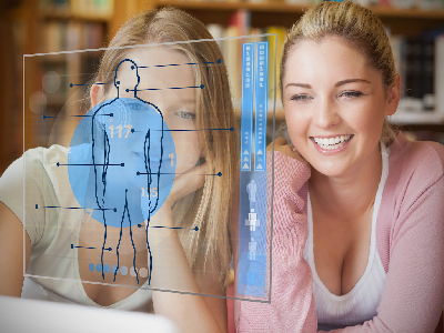 Two college students looking at laptop and futuristic interface with body diagram in blue water